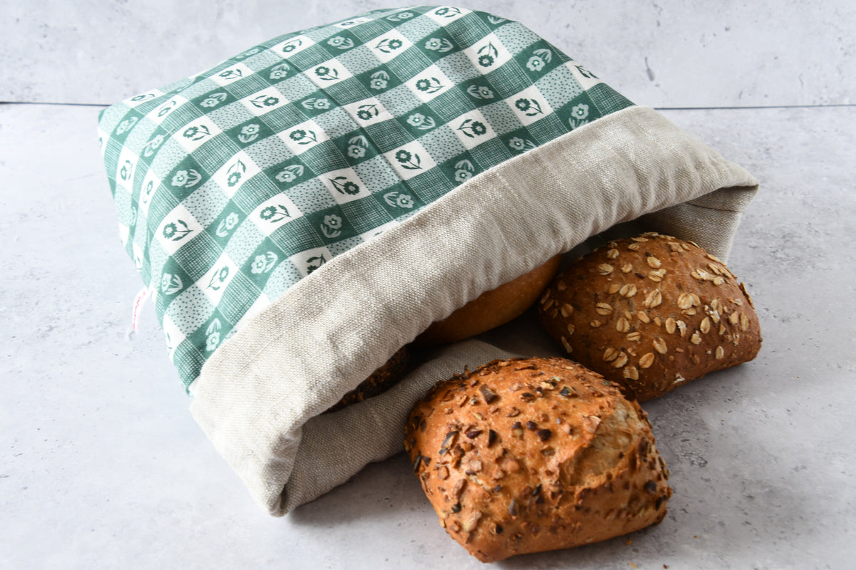 Brotbeutel Carola grün flach liegend mit umgeschlagenem Saum, zeigt das naturbelassene Innenfutter aus reinem Leinen.