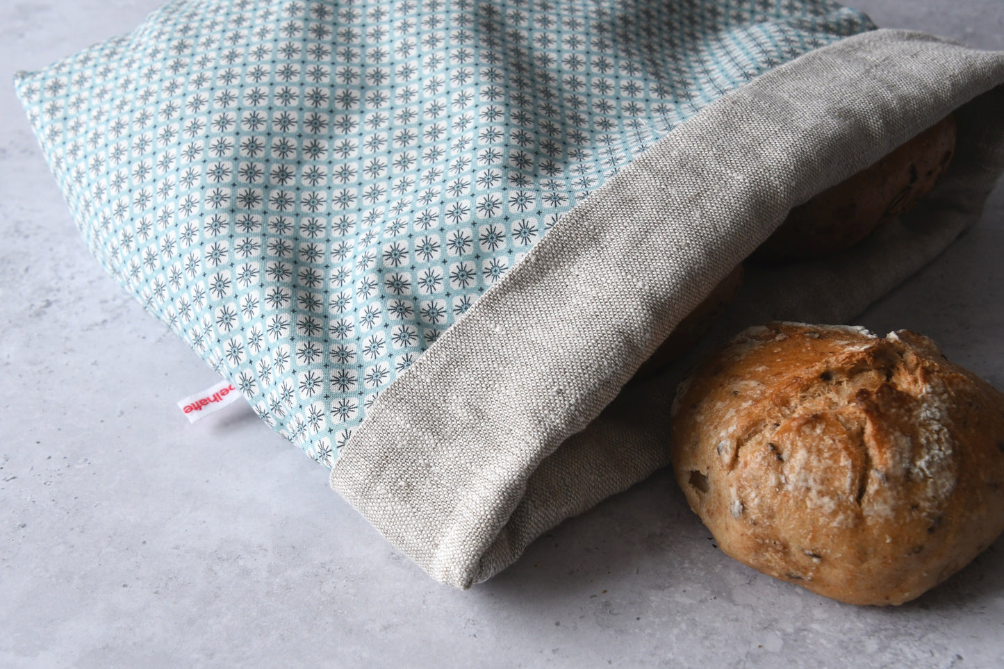 Liegender Brotbeutel "Primel" aus Baumwolle, bei dem das atmungsaktive Innenfutter aus 100% Leinen gut zu sehen ist, von Fabelhaftewerkstatt.