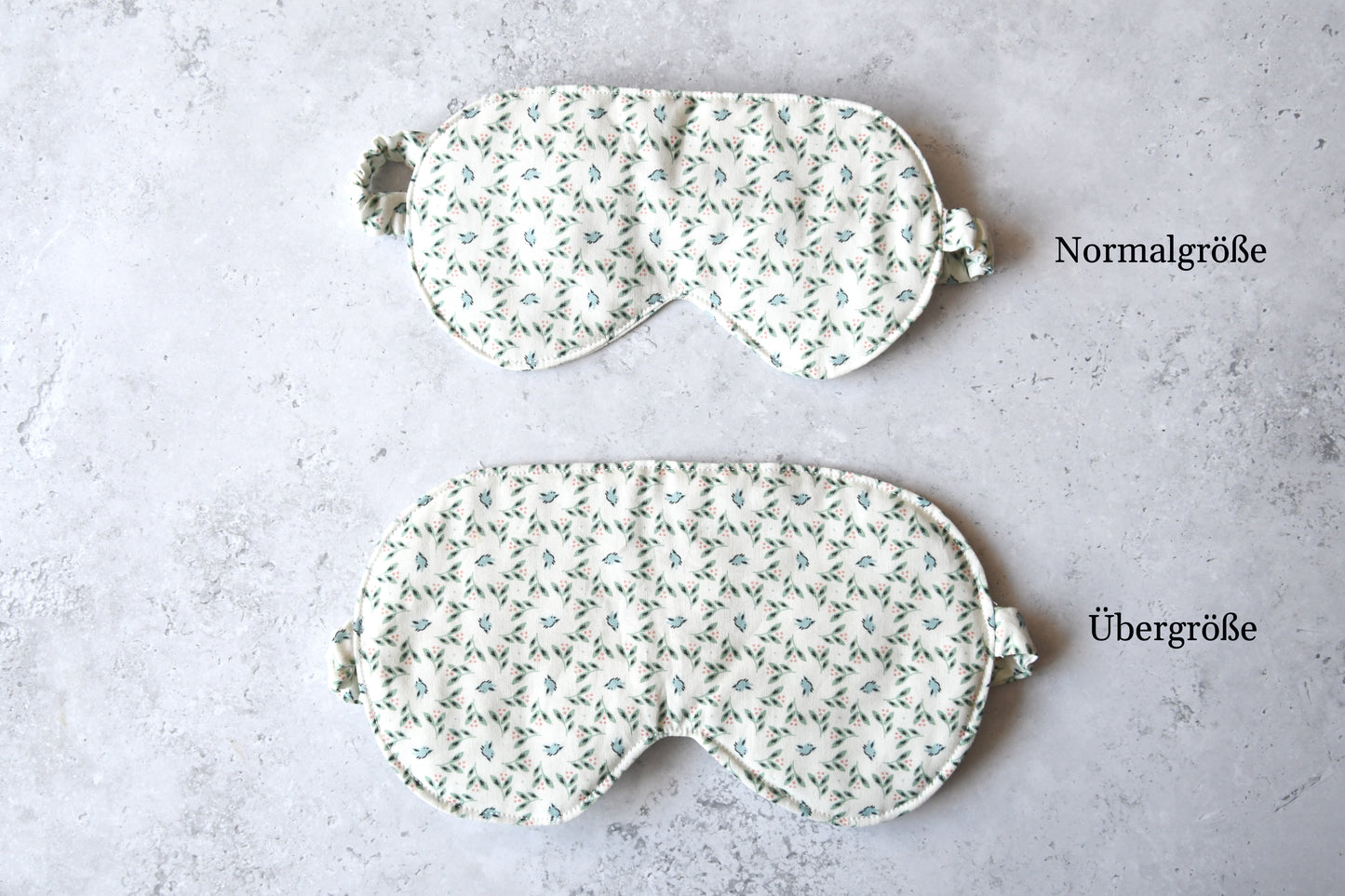 Vergleich der Normalgröße und Übergröße der handgenähten Schlafmaske mit zartem Vogel-Motiv auf weißem Stoff