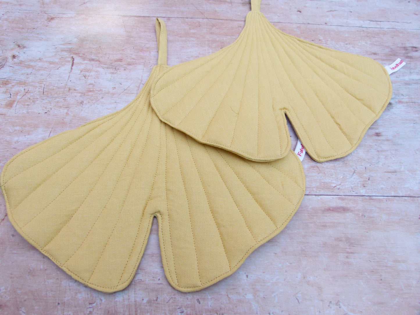 Nahaufnahme der hochwertigen Steppung und der Leinenstruktur des Ginkgoblatt-Topflappens mit sichtbarer Schlaufe zum Aufhängen.