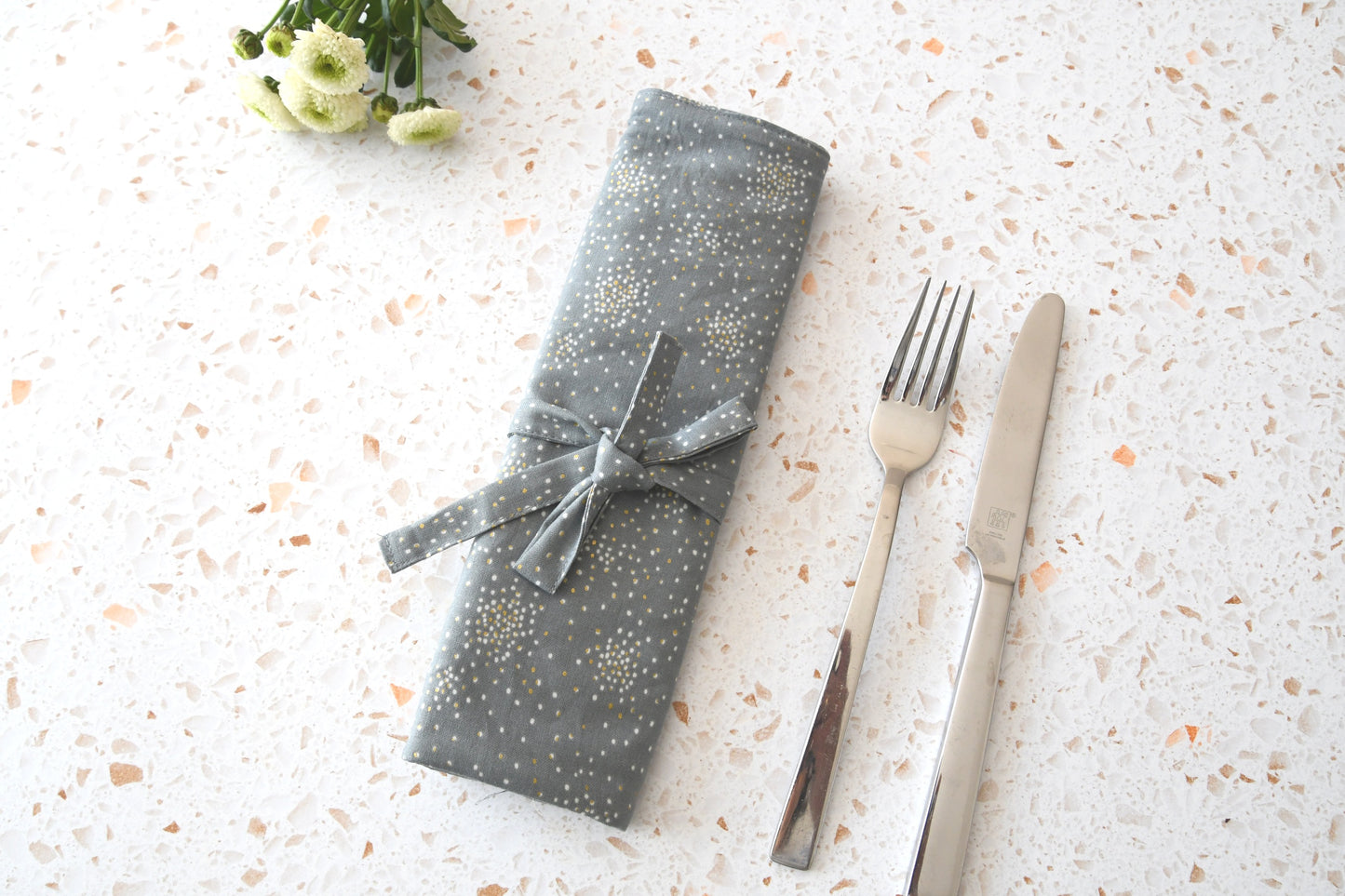 Graue, glitzernde Bestecktasche zum Rollen, sicher verschlossen für den Transport in der Handtasche.
