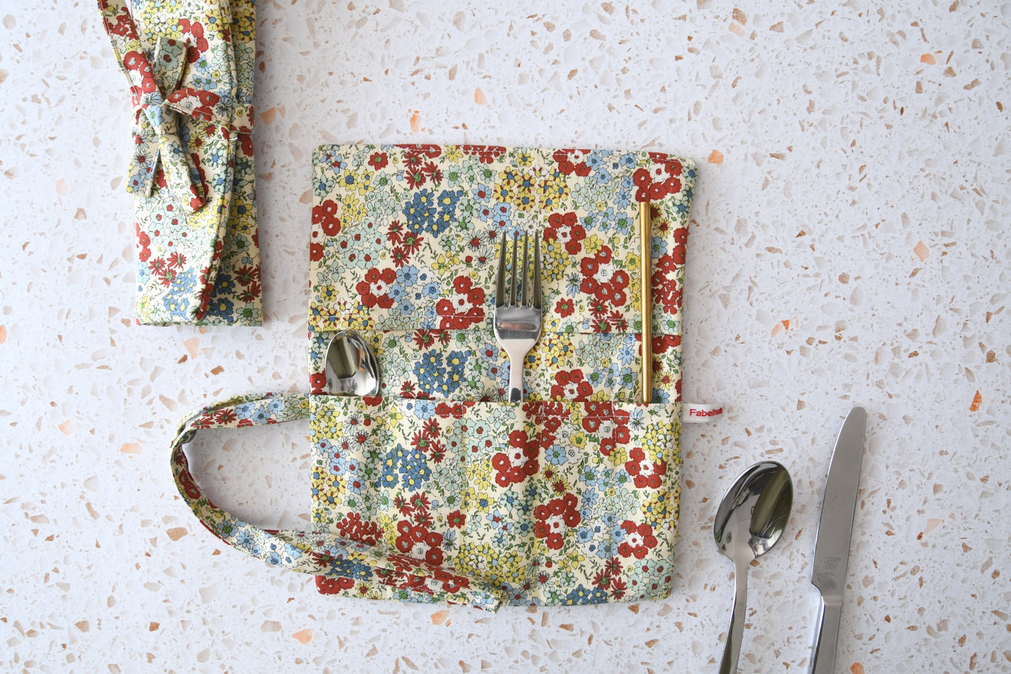 Bestecktasche zum Rollen Blumenmuster: Handgenähte Stoff-Besteckrolle geöffnet und geschlossen im Vergleich, ideal für Picknick und Meal Prep.