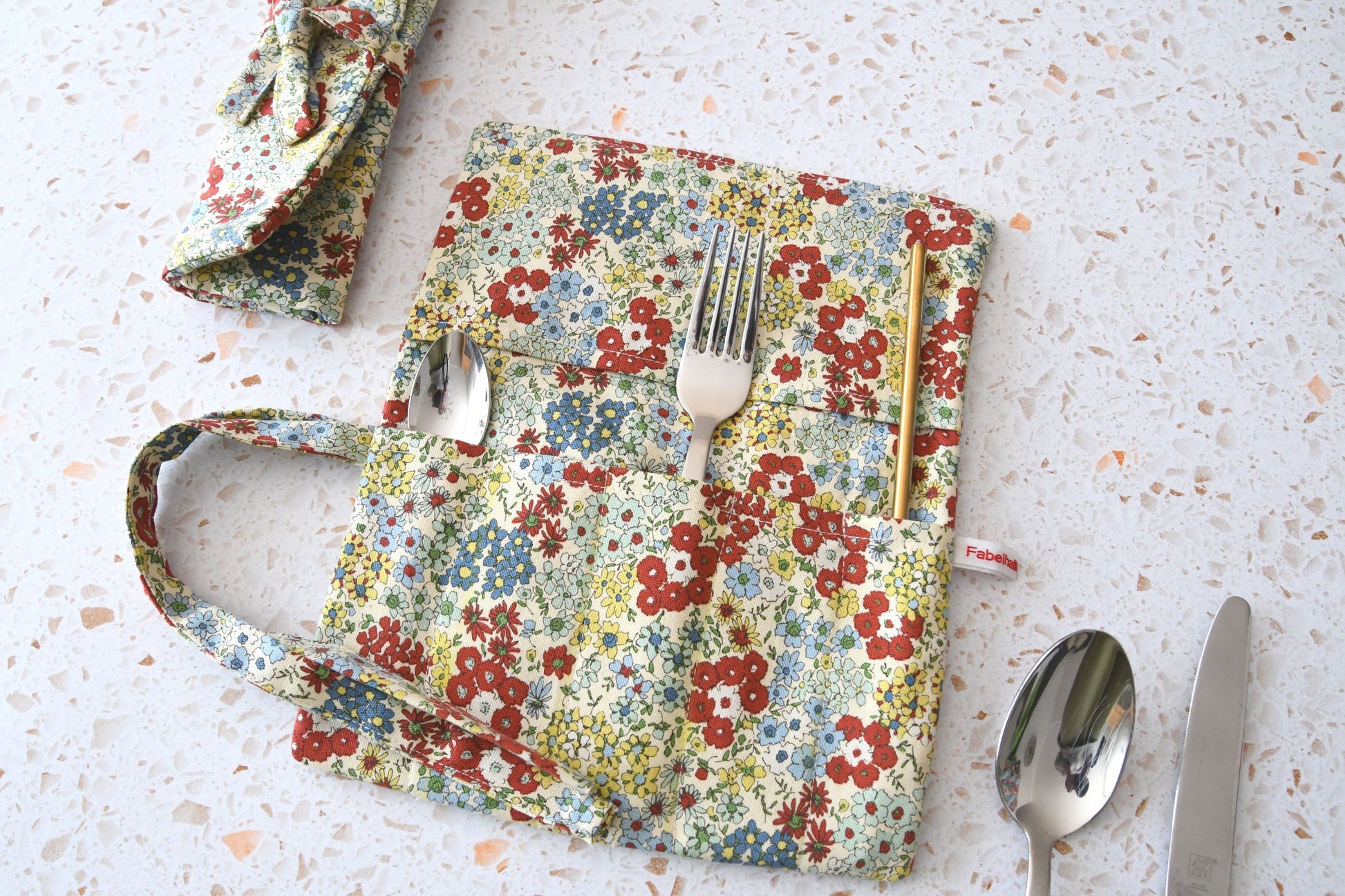 Bestecktasche zum Rollen Blumenmuster: Handgenähte Stoff-Besteckrolle geöffnet und geschlossen im Vergleich, ideal für Picknick und Meal Prep.