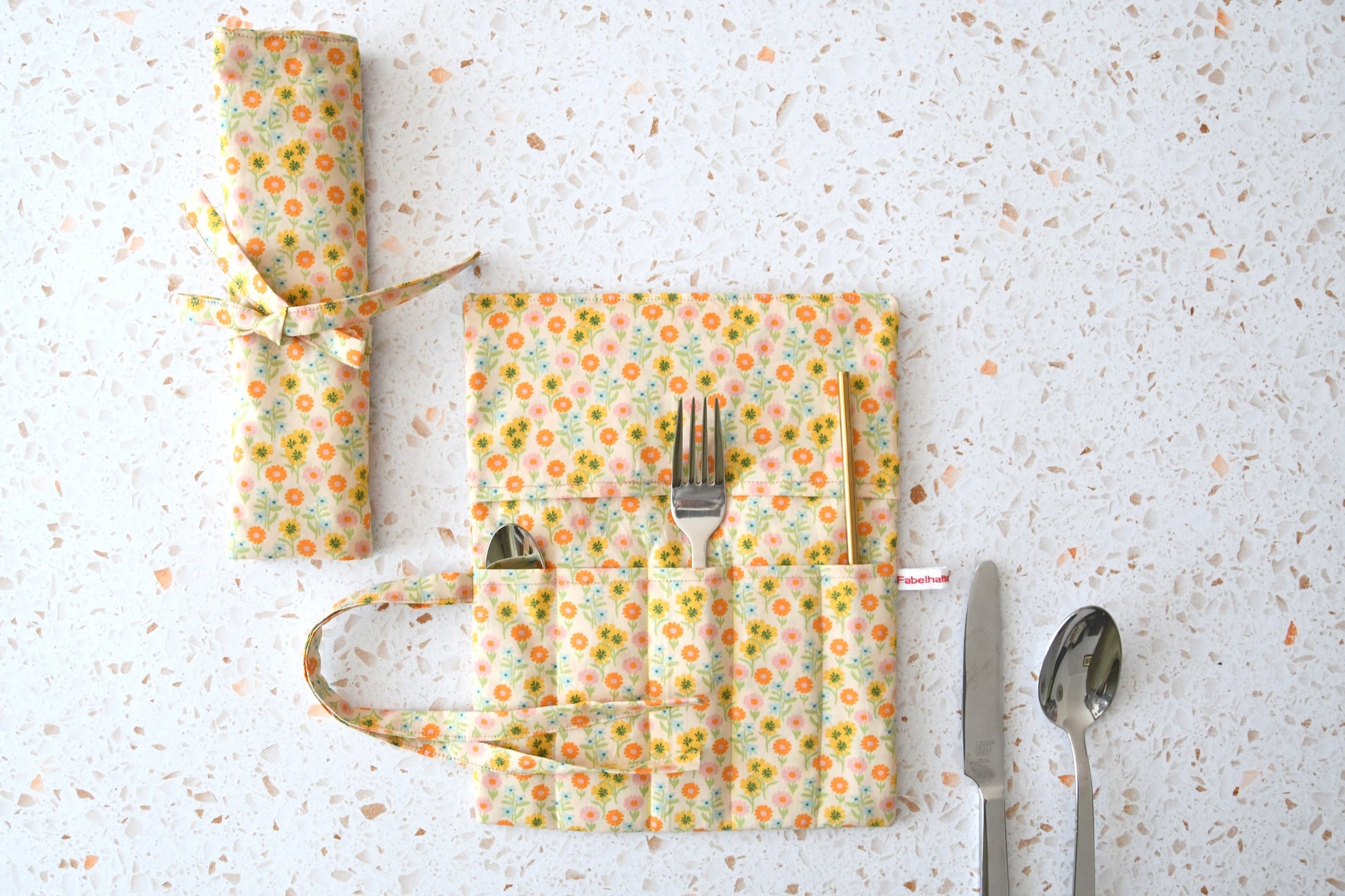 Bestecktasche zum Rollen Blümchenmuster: Handgenähte Stoff-Besteckrolle geöffnet und geschlossen im Vergleich, ideal für Picknick und Meal Prep.