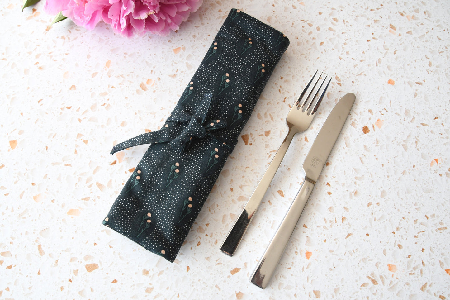 Zusammengerollte und mit einem Band zubundene Bestecktasche mit floralem Blumenmuster von Fabelhaftewerkstatt.