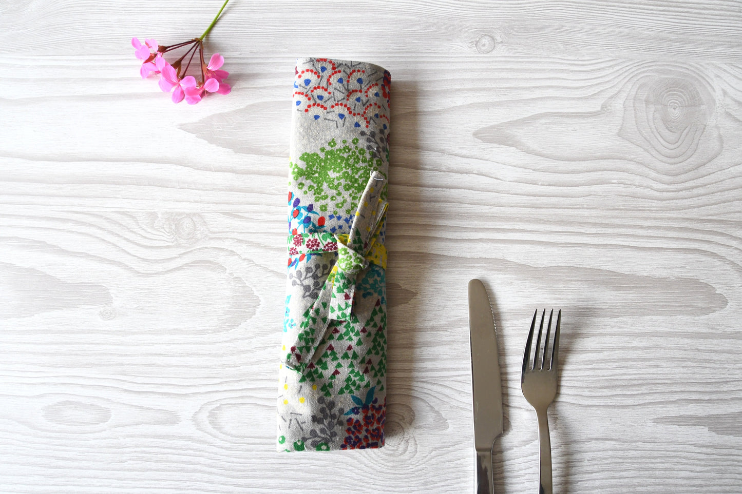 Zusammengerollte und mit einem Band zubundene Bestecktasche mit floralem Blumenmuster von Fabelhaftewerkstatt.