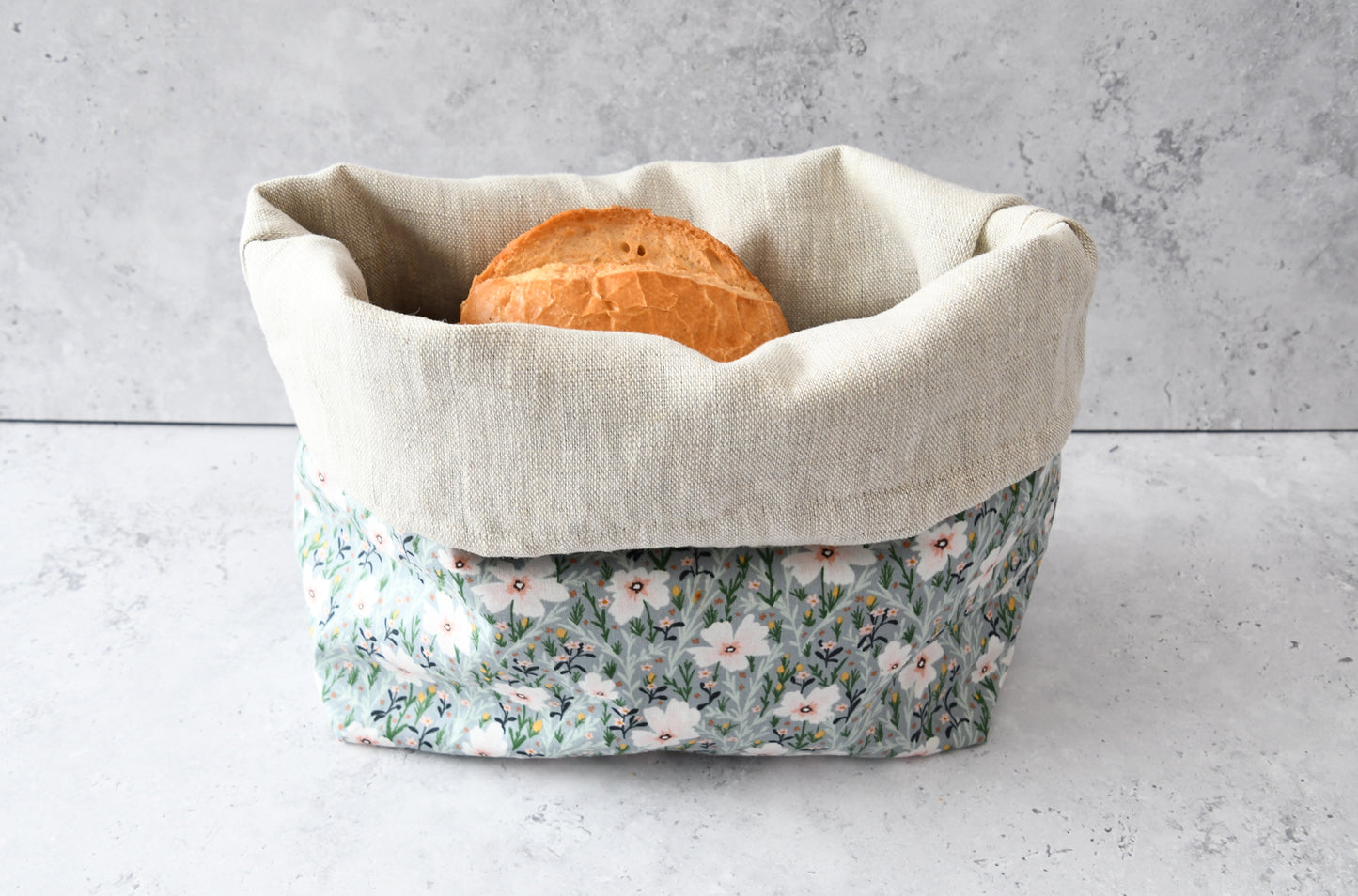 Brotbeutel "Hanna" mit Blumenmuster von Fabelhaftewerkstatt. Genäht aus Baumwolle und Leinen, der umgeklappt als Brotkorb mit frischen Brötchen steht.
