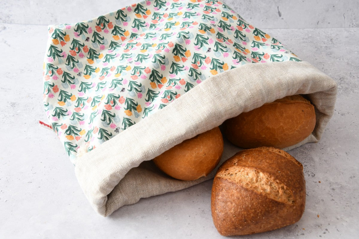 Liegender Brotbeutel "Kleine Tulpen" aus Baumwolle, bei dem das atmungsaktive Innenfutter aus 100% Leinen gut zu sehen ist, von Fabelhaftewerkstatt.