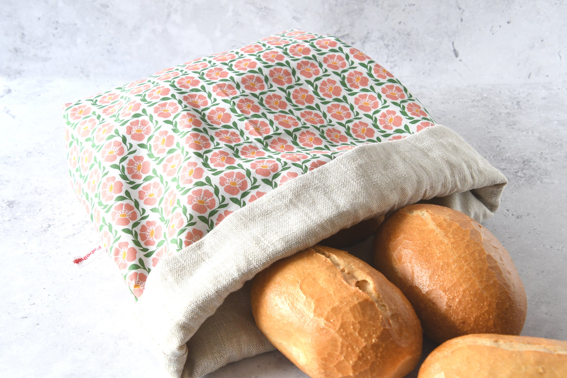 Nahaufnahme des flach liegenden Brotbeutels „Fanny“ aus hochwertigem Leinenstoff mit verspieltem Blumenmuster.