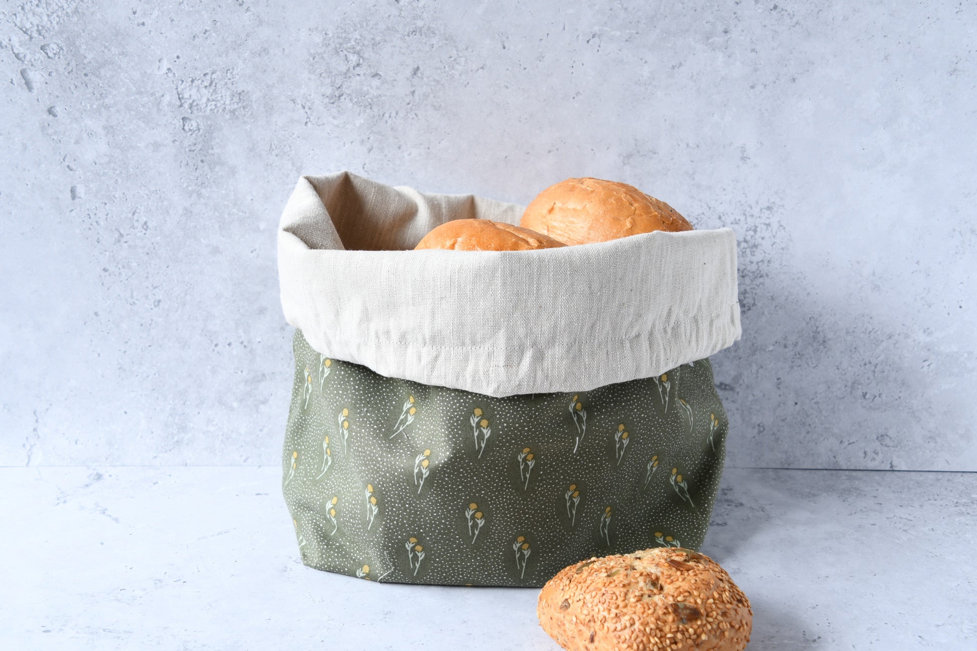 Brotbeutel "Dais" von Fabelhaftewerkstatt aus Baumwolle und Leinen, der umgeklappt als Brotkorb mit frischen Brötchen steht.