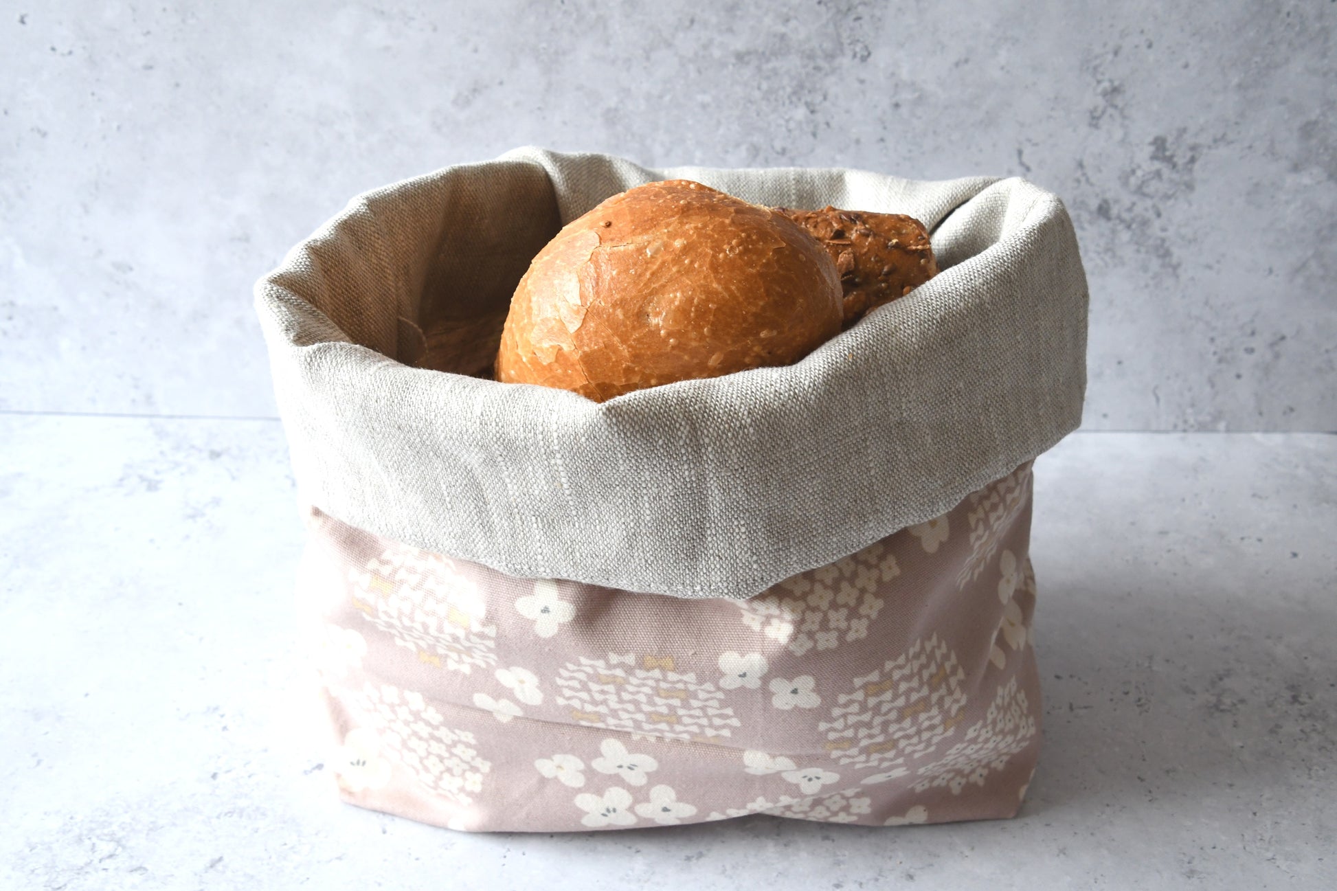 Brotbeutel "Kimiko" von Fabelhaftewerkstatt aus Baumwolle und Leinen, der umgeklappt als Brotkorb mit frischen Brötchen zu sehen ist.