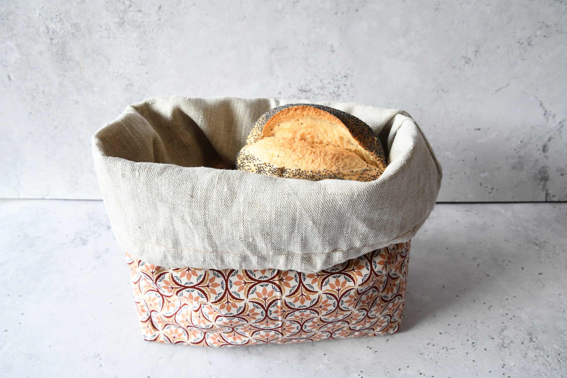 Brotbeutel "Gemma" von Fabelhaftewerkstatt aus Baumwolle und Leinen, der umgeklappt als Brotkorb mit frischen Brötchen steht.