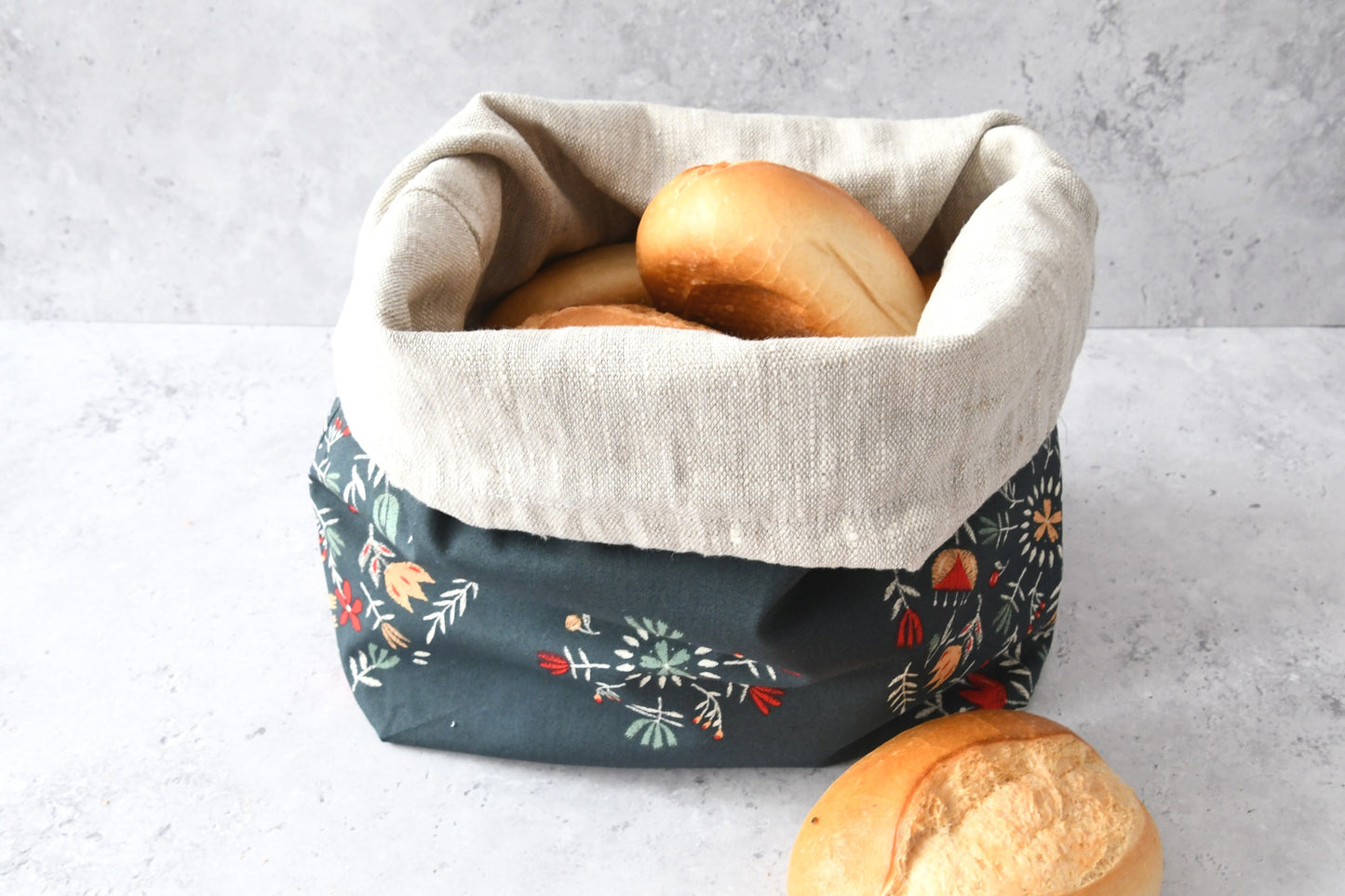 Brotbeutel "Nathalie" von Fabelhaftewerkstatt aus Baumwolle und Leinen, der umgeklappt als Brotkorb mit frischen Brötchen steht.