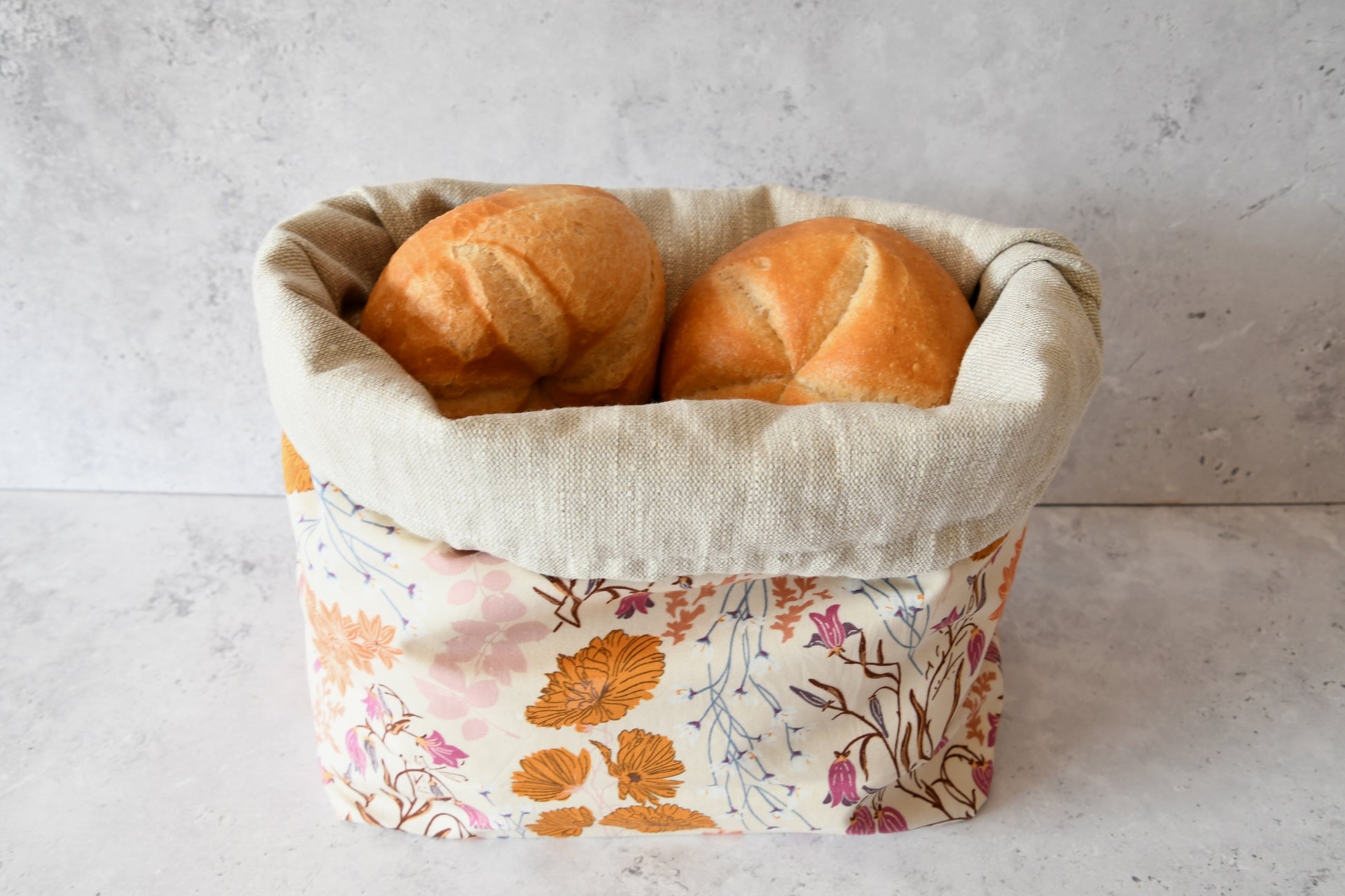 Brotbeutel "September" von Fabelhaftewerkstatt aus Baumwolle und Leinen, der als Brotkorb mit frischen Brötchen steht.