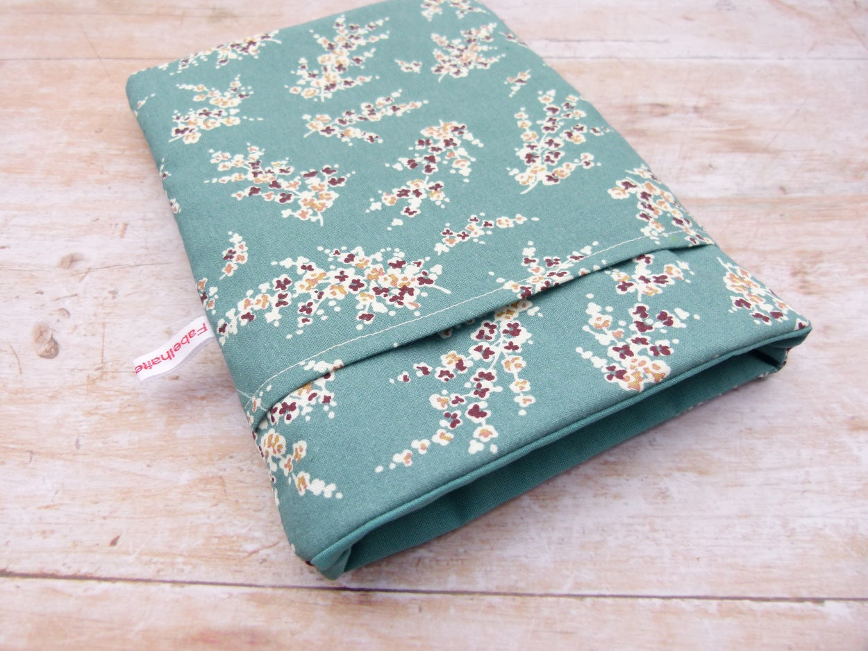 andgefertigte, gepolsterte Buchtasche der Fabelhaften Werkstatt mit einem eleganten Muster aus herabhängenden Wisteria-Zweigen (Blauregen). Auf der flach liegenden Hülle ist das praktische, aufgesetzte Vorderfach gut zu erkennen.