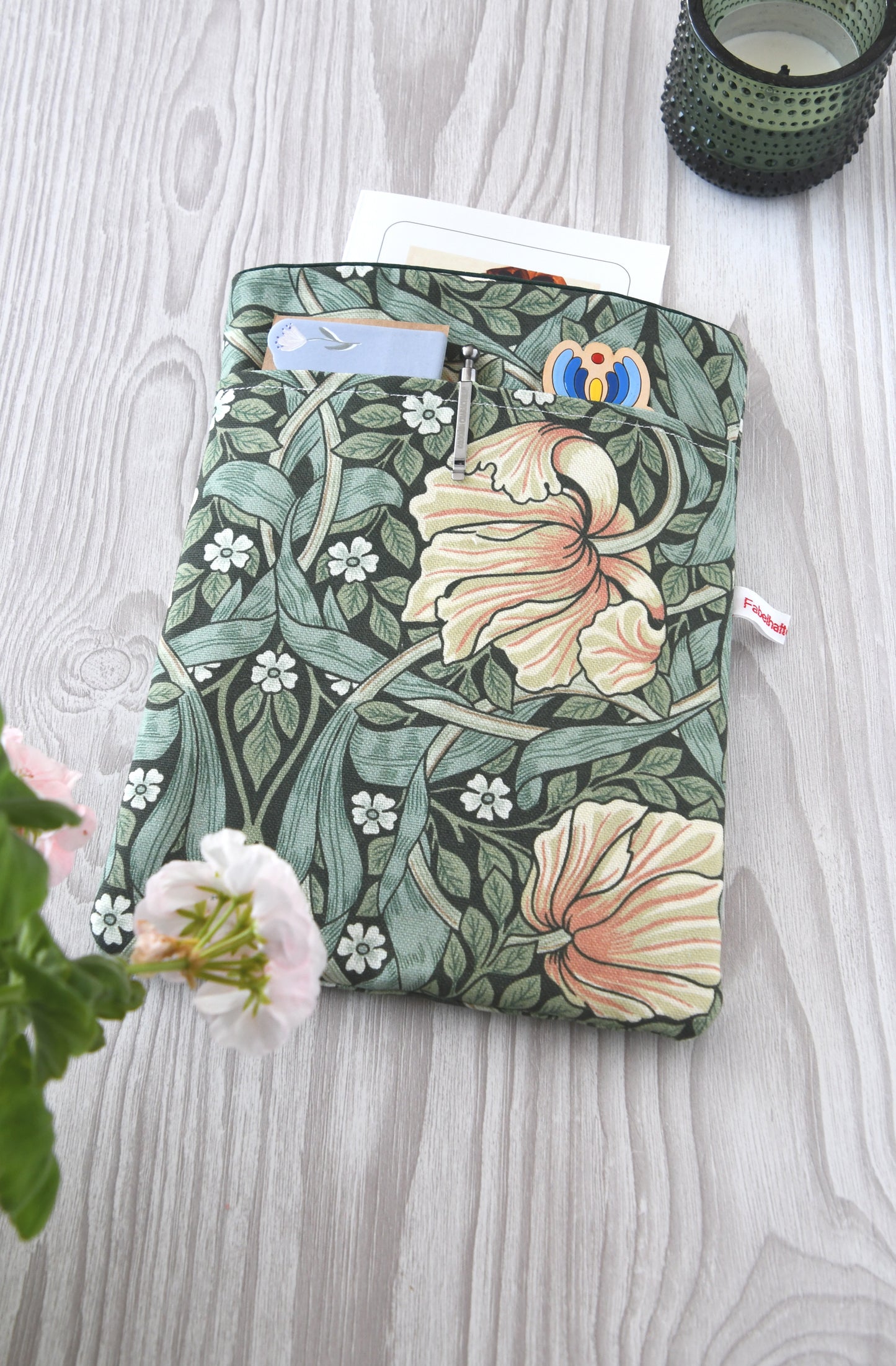 Gepolsterte Buchtasche aus Baumwolle mit elegantem William Morris Blumenmuster, flach von oben fotografiert.