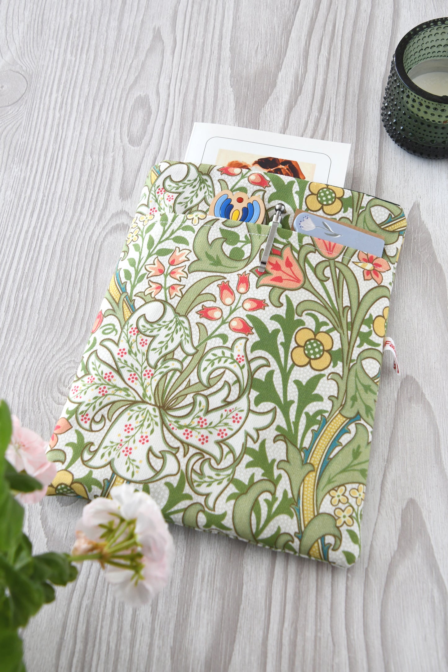 Gepolsterte Buchtasche aus Baumwolle mit elegantem William Morris Blumenmuster, flach von oben fotografiert.