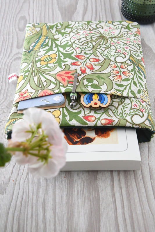 Draufsicht auf die geöffnete Buchtasche im William Morris Stil mit eingestecktem Buch sowie einem Stift und Lesezeichen in der Vordertasche.
