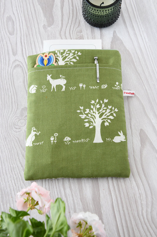 Gepolsterte Buchtasche mit einem gemütlichen Wald-Motiv. Auf dem grünen Stoff sind kleine Tiere und Bäume zu sehen. Die Tasche zeigt das eingenähte „Fabelhafte Werkstatt“-Logo.