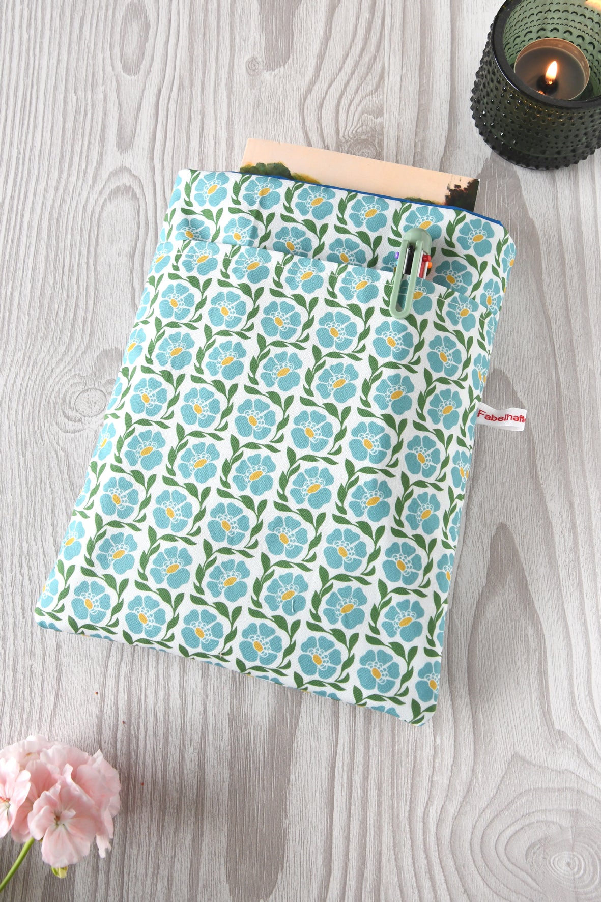 Handgenähte Buchtasche "Franziska" aus Baumwollstoff mit blauem Blumenmuster. Sichtbar ist das Hauptfach sowie die praktische Vordertasche über die gesamte Breite für Stifte und Lesezeichen.