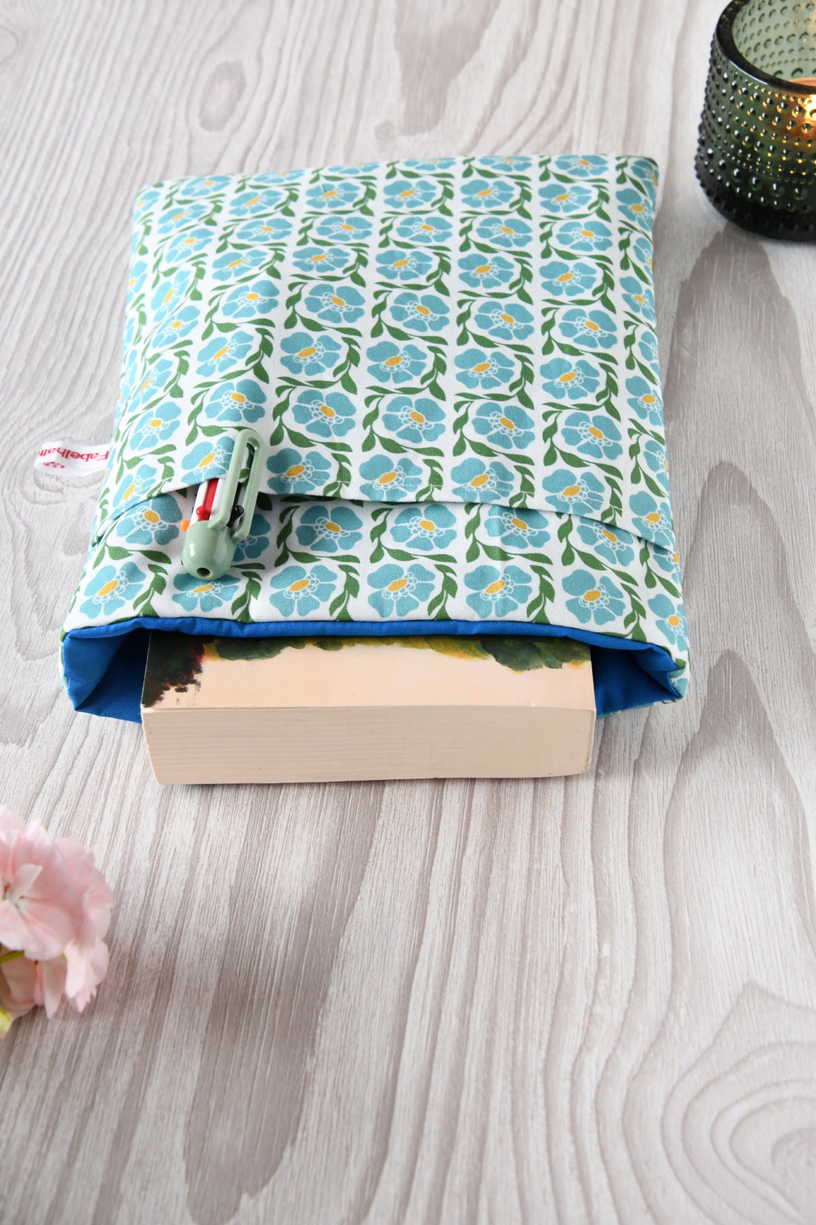 Buchtasche "Franziska" in Standardgröße M mit blauem Blumenmuster. Ein gängiges Taschenbuch steckt perfekt geschützt in der gepolsterten Buchhülle.