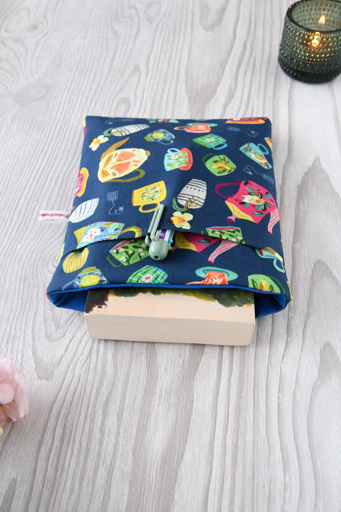 Buchtasche „Teatime“ in Standardgröße M mit Teetassen-Print auf blauem Grund. Ein gängiges Taschenbuch steckt gut geschützt in der handgenähten Stoffhülle.