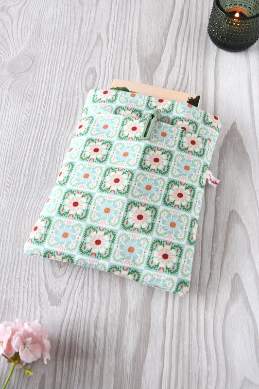Handgenähte Buchtasche „Elisa“ mit zartem Karo- und Blumenmuster auf mintfarbenem Baumwollstoff. Zu sehen ist die gepolsterte Buchhülle mit praktischer Vordertasche über die gesamte Breite.