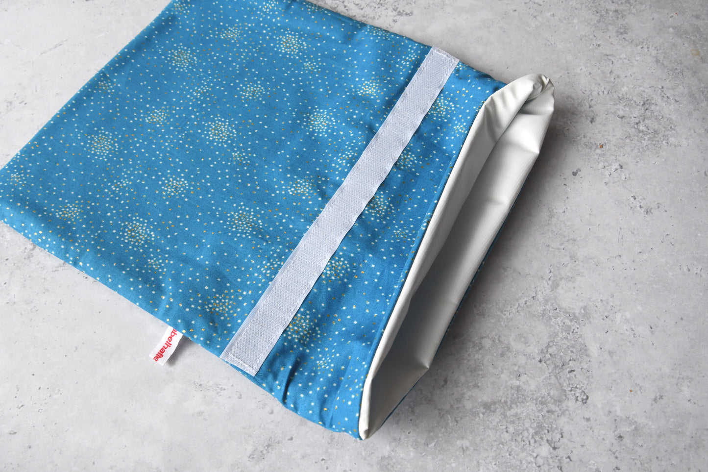 Geöffneter Gefrierbeutel "Glitter auf blau" von Fabelhaftewerkstatt, bei dem das schadstofffreie und lebensmittelechte Innenfutter gut zu sehen ist.