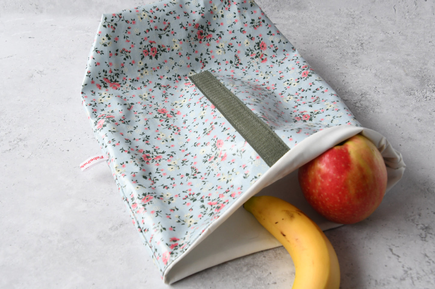 Geöffneter Lunchbag "Liberta blau" von Fabelhaftewerkstatt, gefüllt mit gesundem Obst für unterwegs.