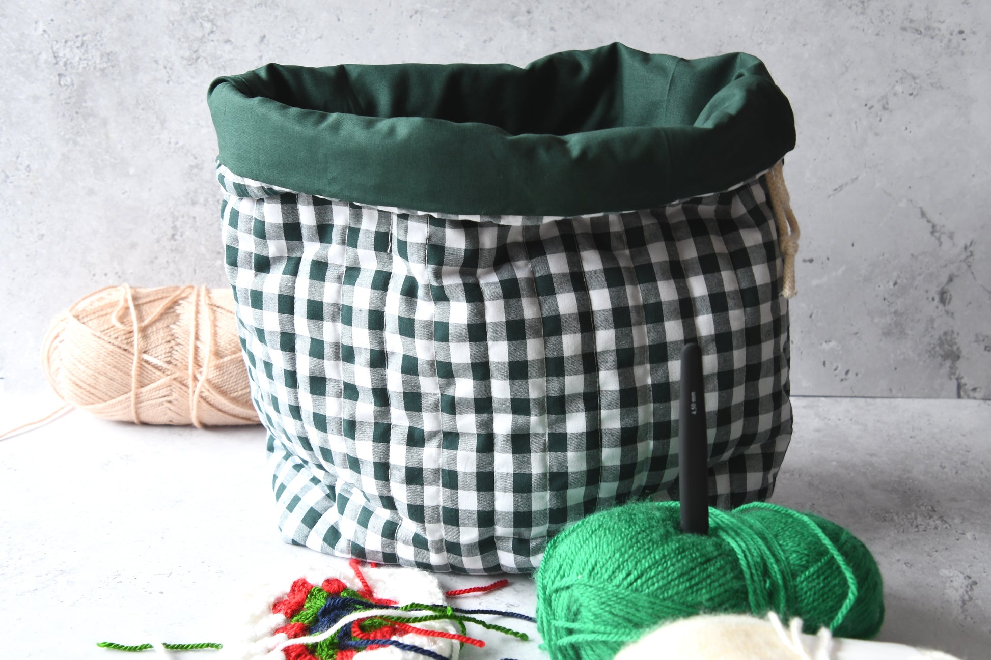 Karierter Strickbeutel in Grün mit edler Steppung und robuster Baumwollkordel zum Zuziehen.