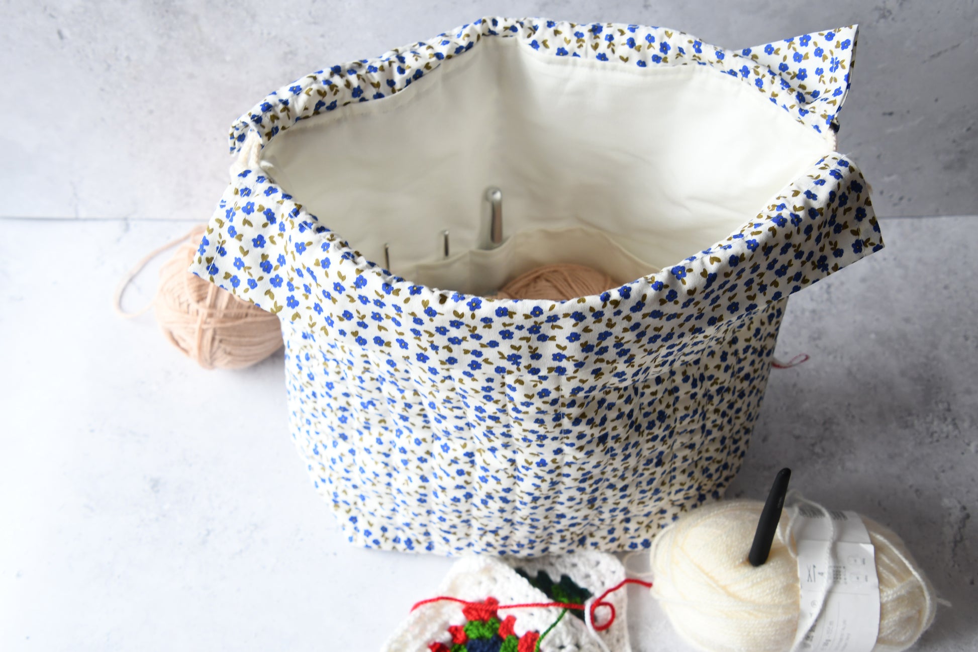 Detailaufnahme der geöffneten floralen Projekttasche mit den praktischen Einsteckfächern für eine perfekte Nadel-Organisation.