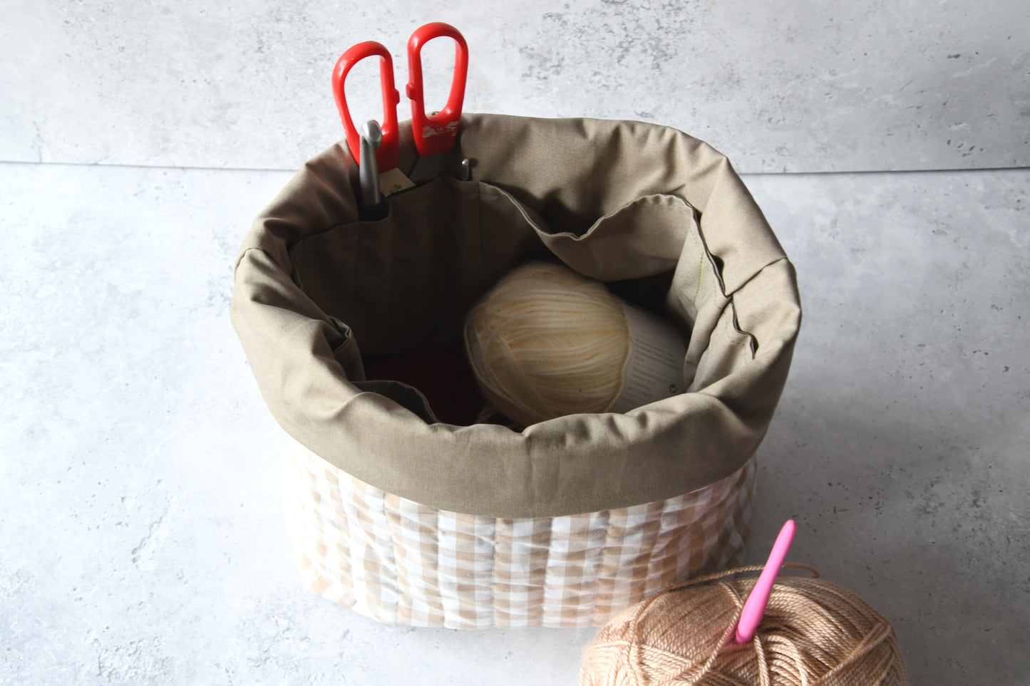 Blick in die geöffnete beige Karo-Projekttasche mit dem feinen Innenfutter und den rundum angeordneten Steckfächern.