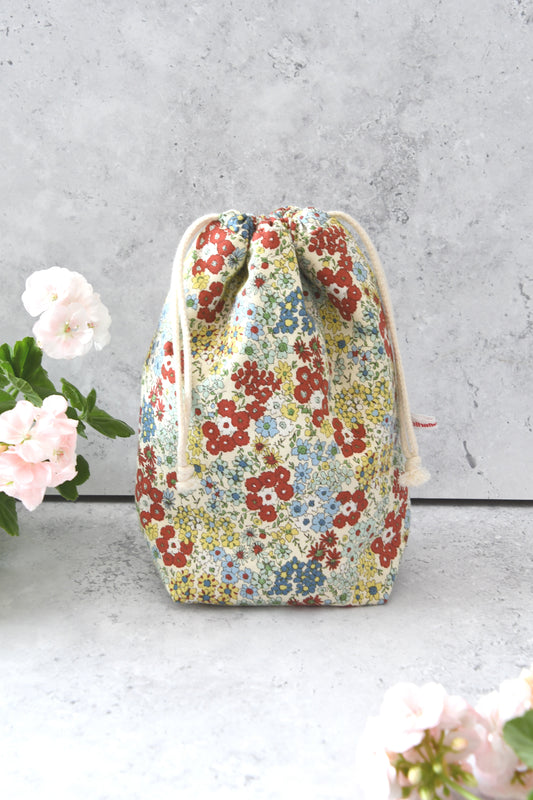 Handgenähter japanischer Kinchaku-Reisebeutel mit zarten rotfarbenen Streublumen von der Fabelhaften Werkstatt Bremen.