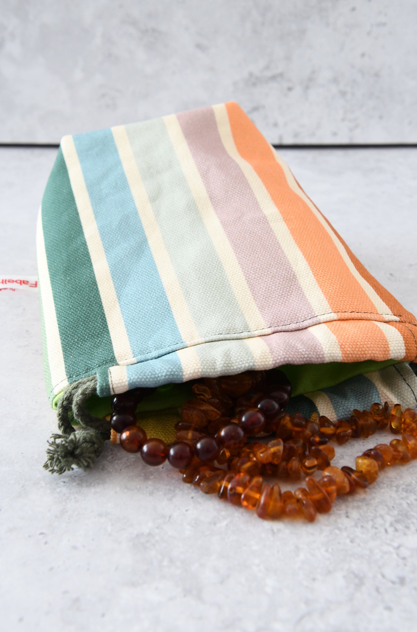 Taschenorganizer mit Pastellstreifen gefüllt mit Schmuck.