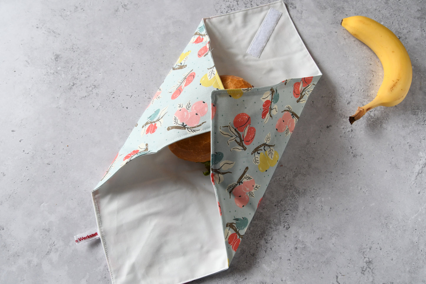 Belegtes Brötchen im Sandwich Wrap, an zwei Seiten sauber eingeschlagen.