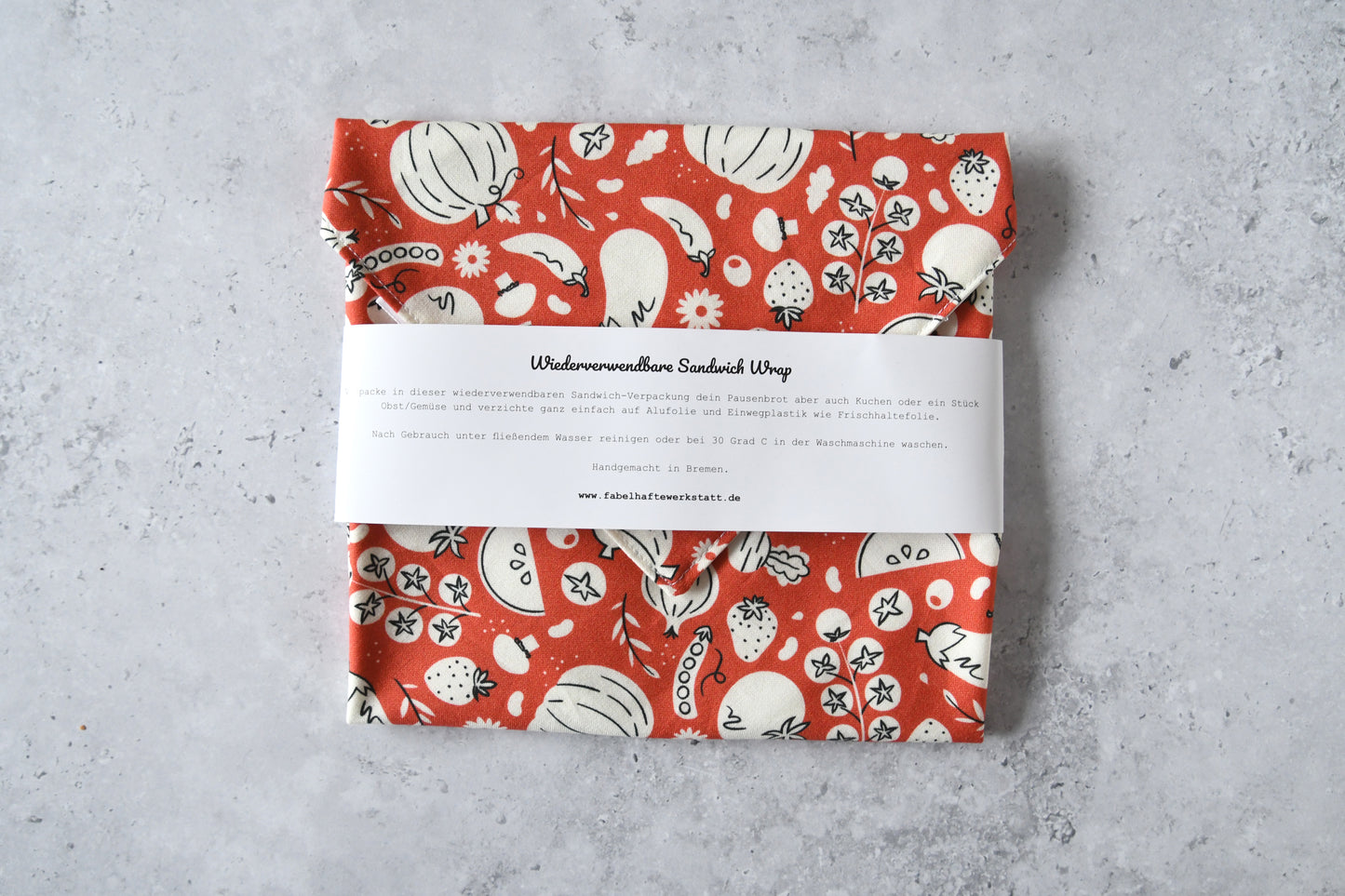 Verpackter Stoff-Sandwich-Wrap mit Banderole als umweltfreundliche Alternative zu Alufolie.
