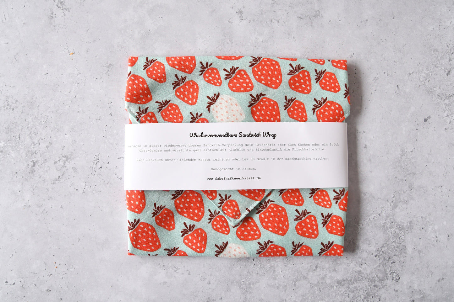 Verpackter Stoff-Sandwich-Wrap mit Banderole als umweltfreundliche Alternative zu Alufolie.