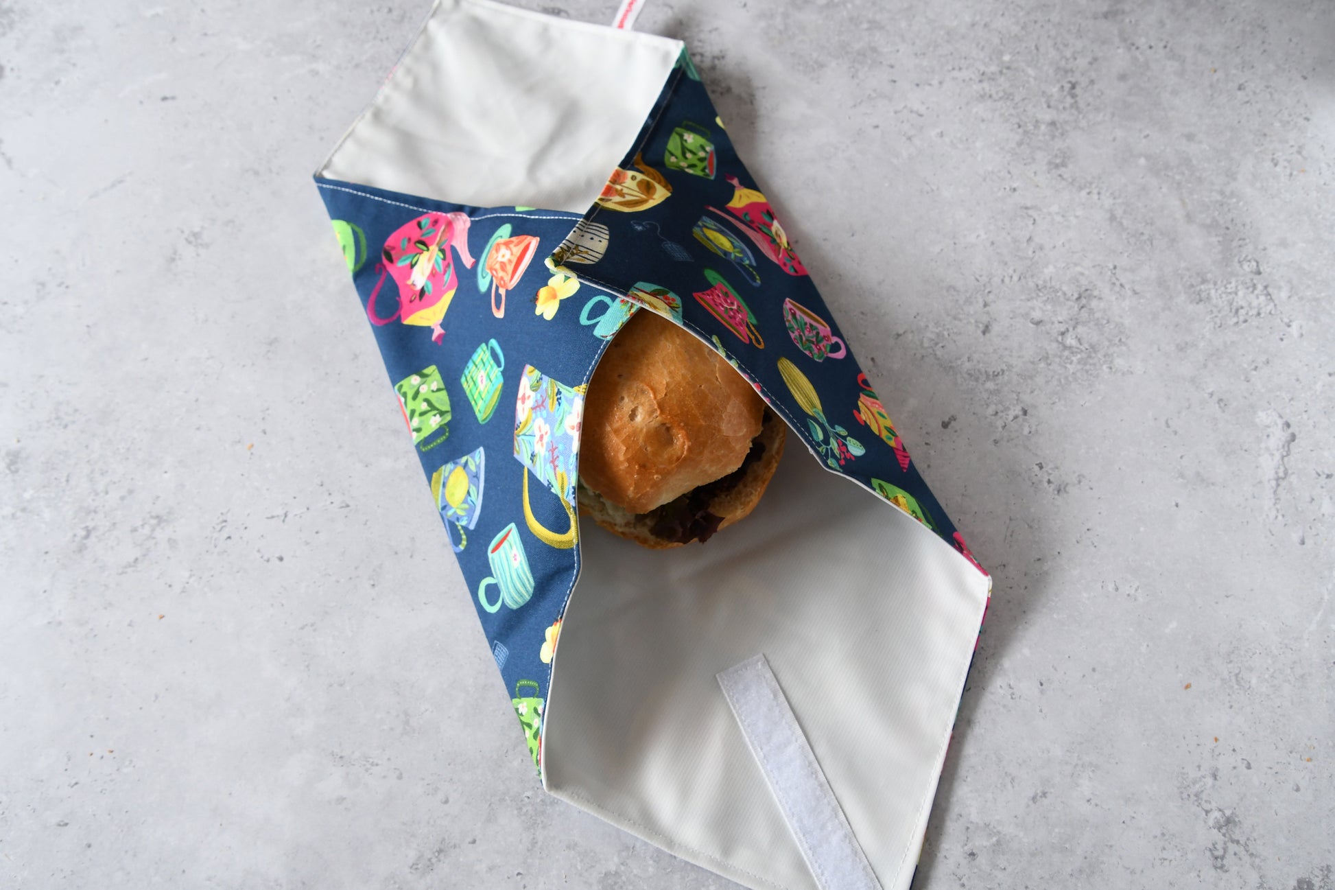 Belegtes Brötchen im Sandwich Wrap, an zwei Seiten sauber eingeschlagen.