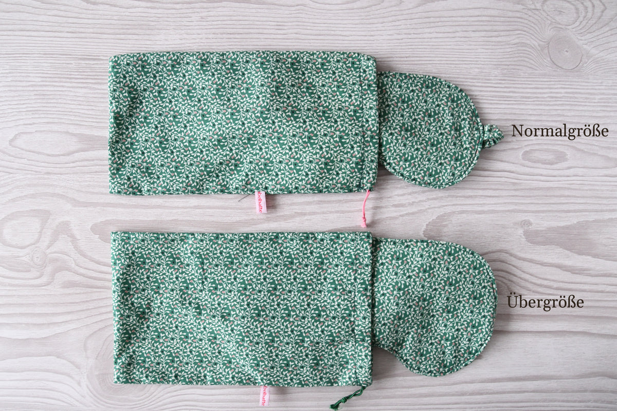 Vergleich der Normalgröße und Übergröße der handgenähten Schlafmaske Anthea mit botanischem Print auf Grün