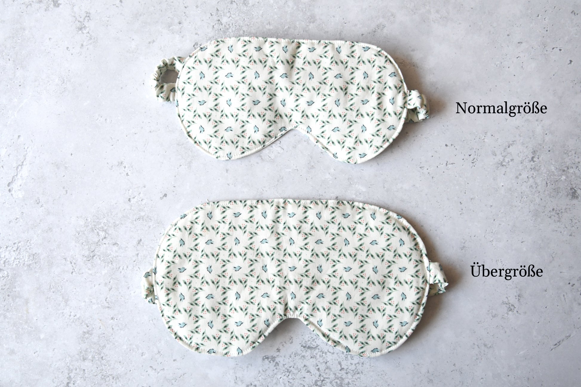Vergleich der Normalgröße und Übergröße der handgenähten Schlafmaske mit zartem Vogel-Motiv auf weißem Stoff