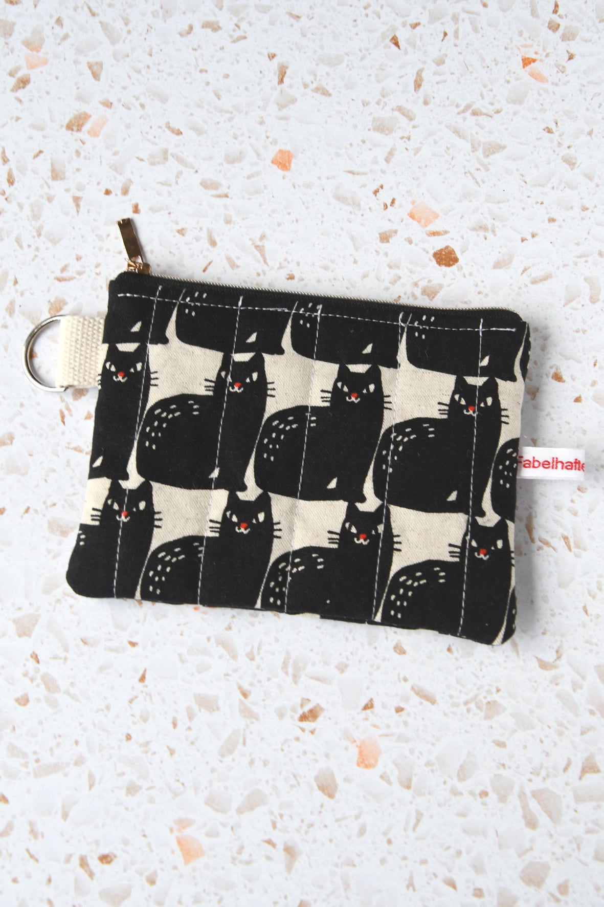 Geöffnetes Schlüsseltäschchen mit schwarzen Katzen.