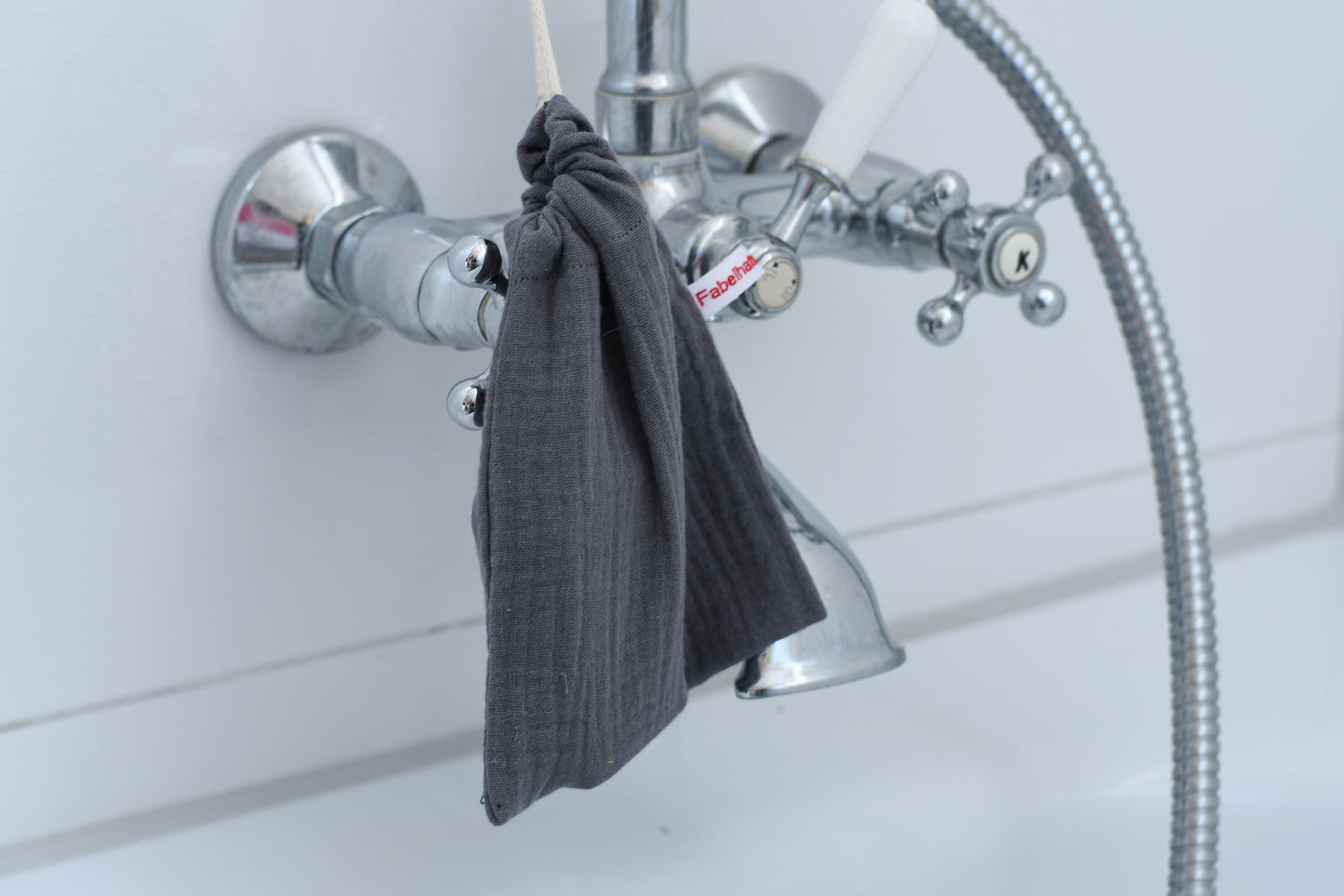 Nachhaltiges Seifensäckchen aus Stoff, mit einer Kordel fest verschlossen und dekorativ im Badezimmer aufgehängt.