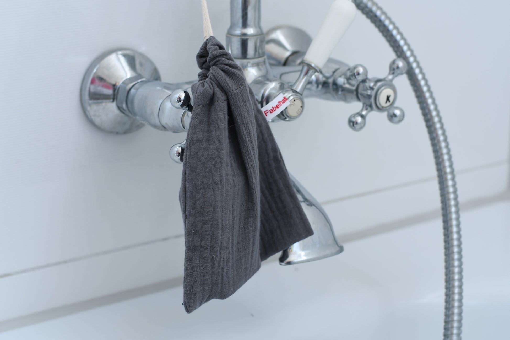 Nachhaltiges Seifensäckchen aus Stoff, mit einer Kordel fest verschlossen und dekorativ im Badezimmer aufgehängt.
