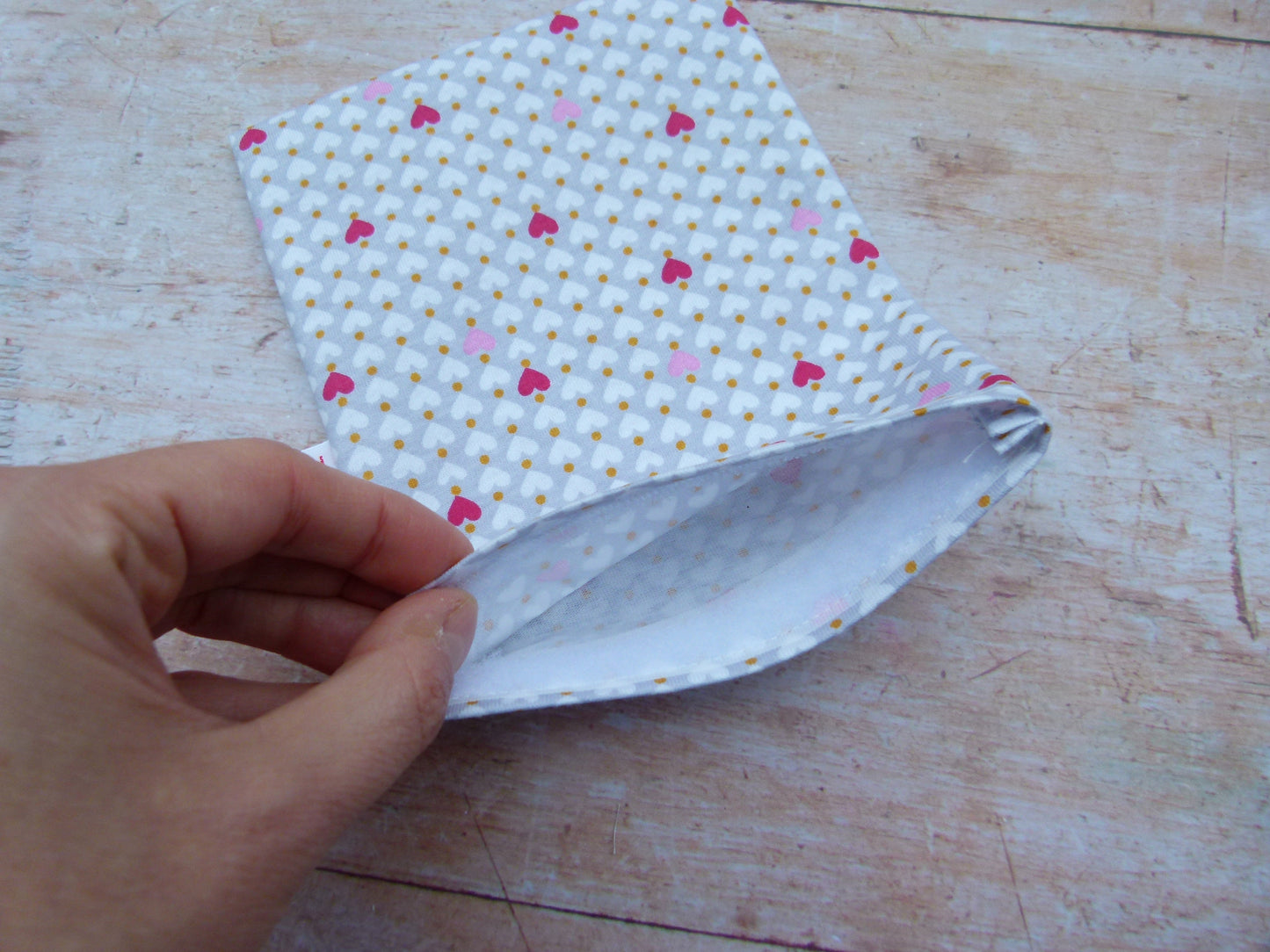 Detailansicht eines handgemachten Snackbags, bei dem eine Hand das saubere, weiße Innere aus zertifiziertem, lebensmittelechtem und wasserabweisendem PUL-Stoff zeigt.
