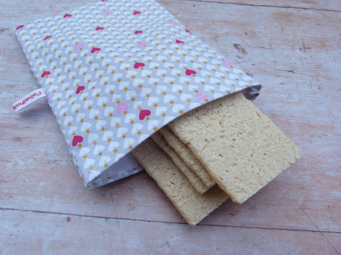 Handgenähter, nachhaltiger Snackbag von Fabelhaftewerkstatt aus lebensmittelechtem Stoff, geöffnet und befüllt mit Knäckebroten auf einem Küchentisch.