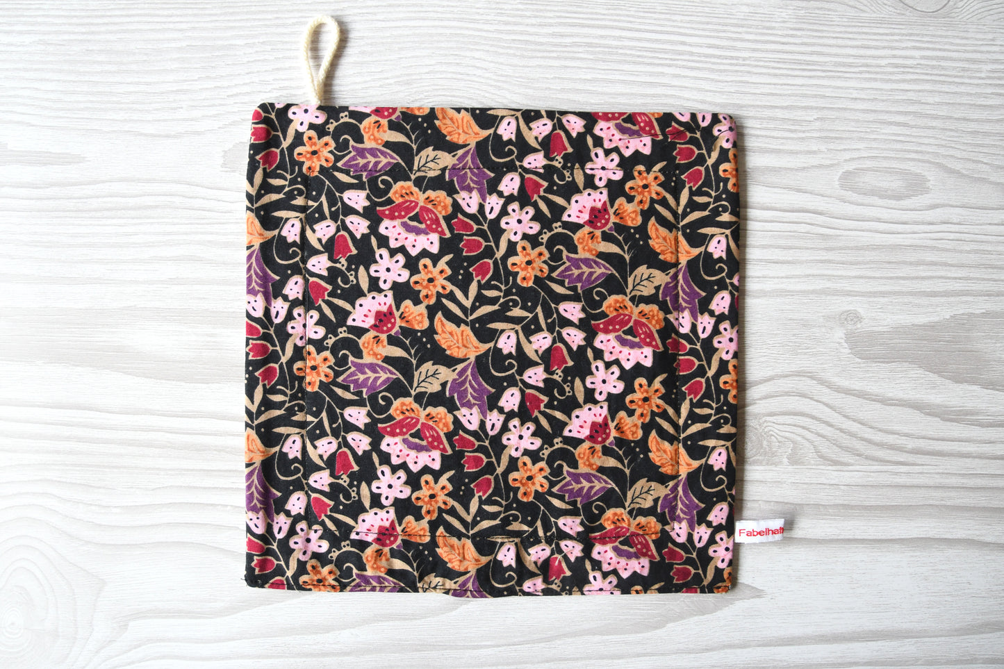 Elegantes, handgenähtes Spültuch mit einem farbenfrohen Blumenmuster auf einem dunklen, kontrastreichen Hintergrund von Fabelhaftewerkstatt.