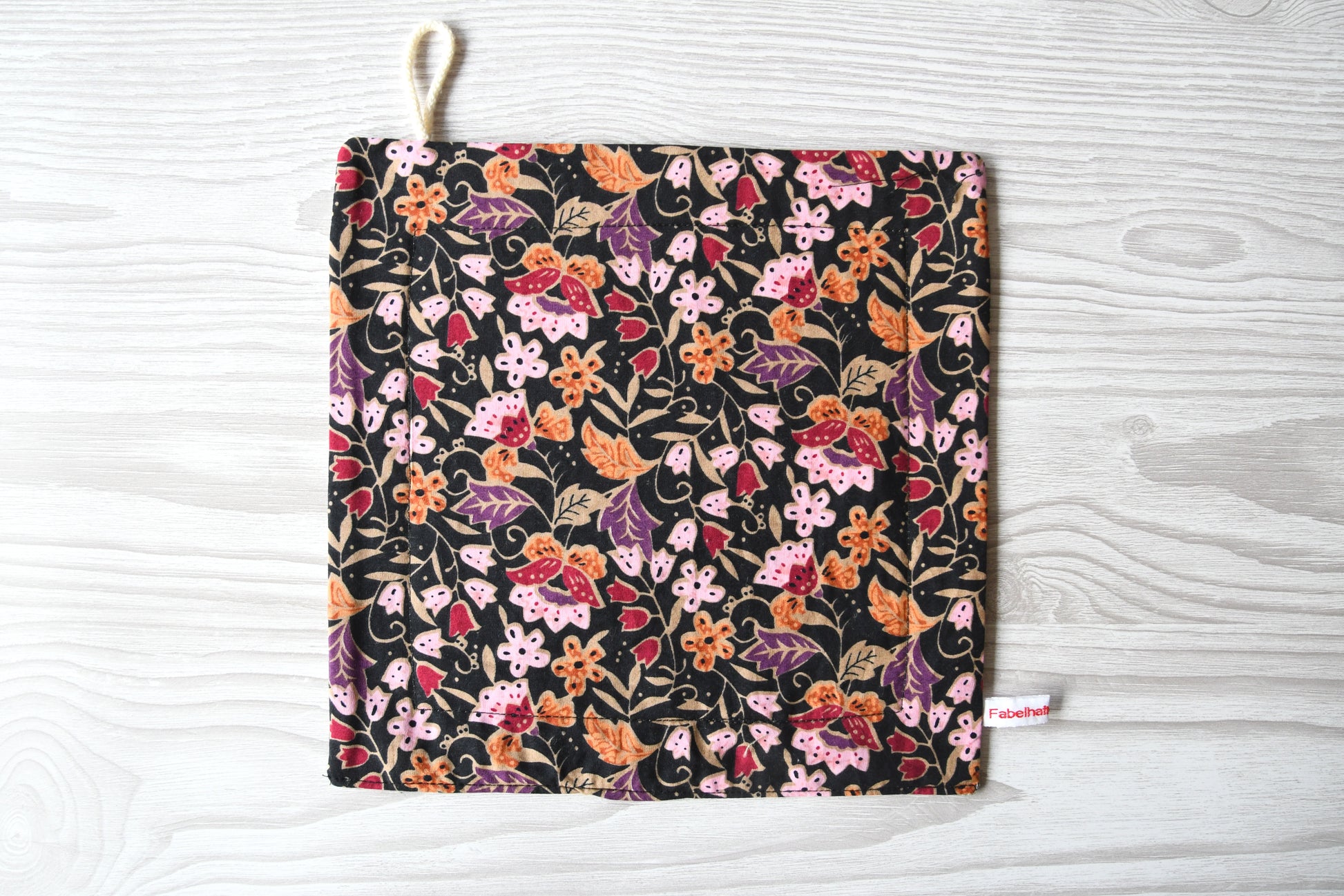 Elegantes, handgenähtes Spültuch mit einem farbenfrohen Blumenmuster auf einem dunklen, kontrastreichen Hintergrund von Fabelhaftewerkstatt.