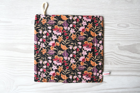 Elegantes, handgenähtes Spültuch mit einem farbenfrohen Blumenmuster auf einem dunklen, kontrastreichen Hintergrund von Fabelhaftewerkstatt.