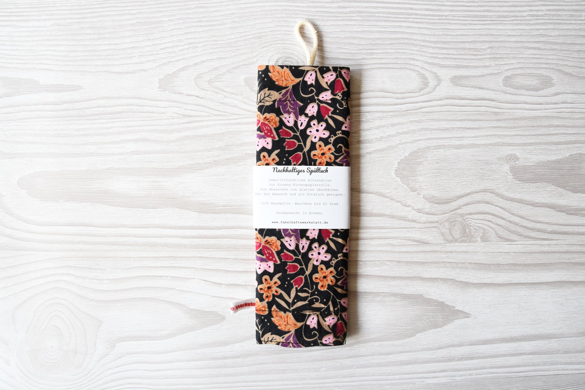 Elegantes, handgenähtes Spültuch mit einem farbenfrohen Blumenmuster auf einem dunklen, kontrastreichen Hintergrund von Fabelhaftewerkstatt.
