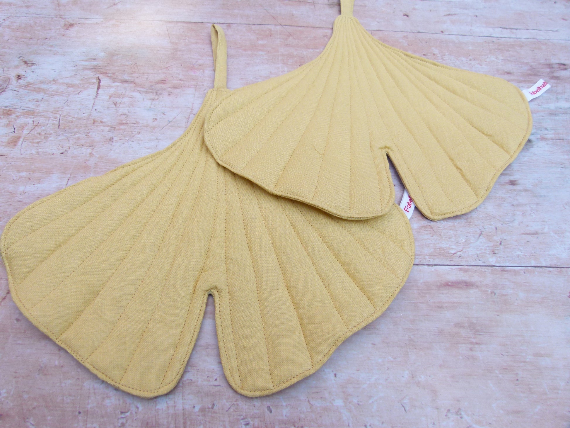 Nahaufnahme der hochwertigen Steppung und der Leinenstruktur des Ginkgoblatt-Topflappens mit sichtbarer Schlaufe zum Aufhängen.
